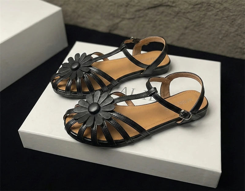 Black sandals with floral designs on a white platform