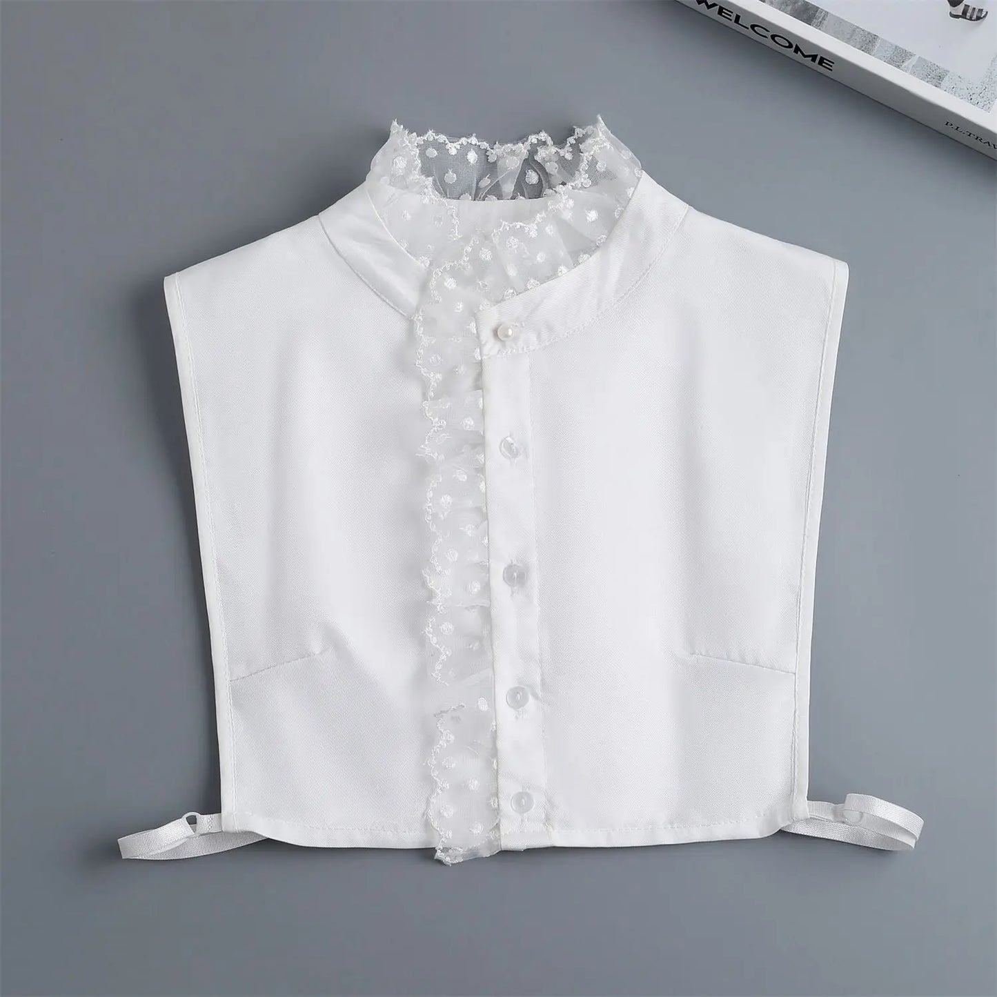 White blouse with lace collar on a gray background