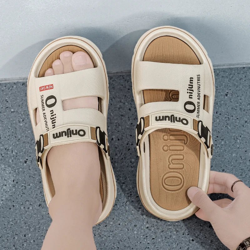 Beige sandals with brand logo on a gray surface