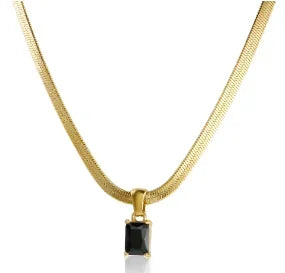 Gold necklace with a black square pendant on a white background